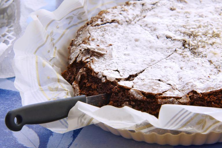 a deep dark chocolate cake with confectioner's sugar on top